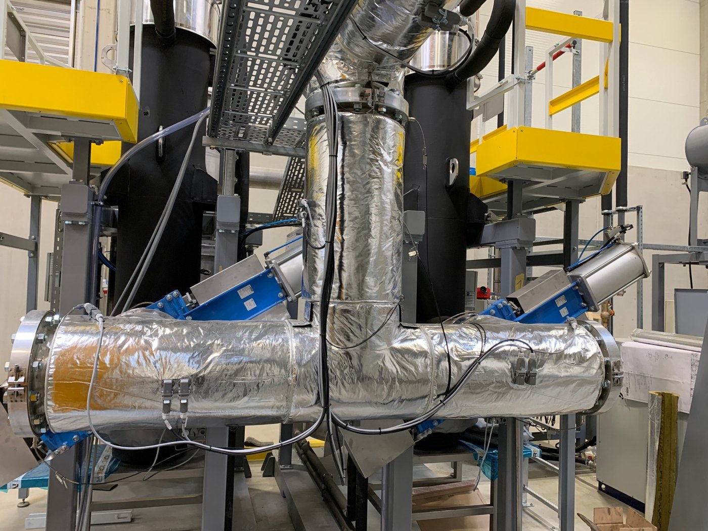 Detail průmyslového potrubí s armaturami v technologické hale